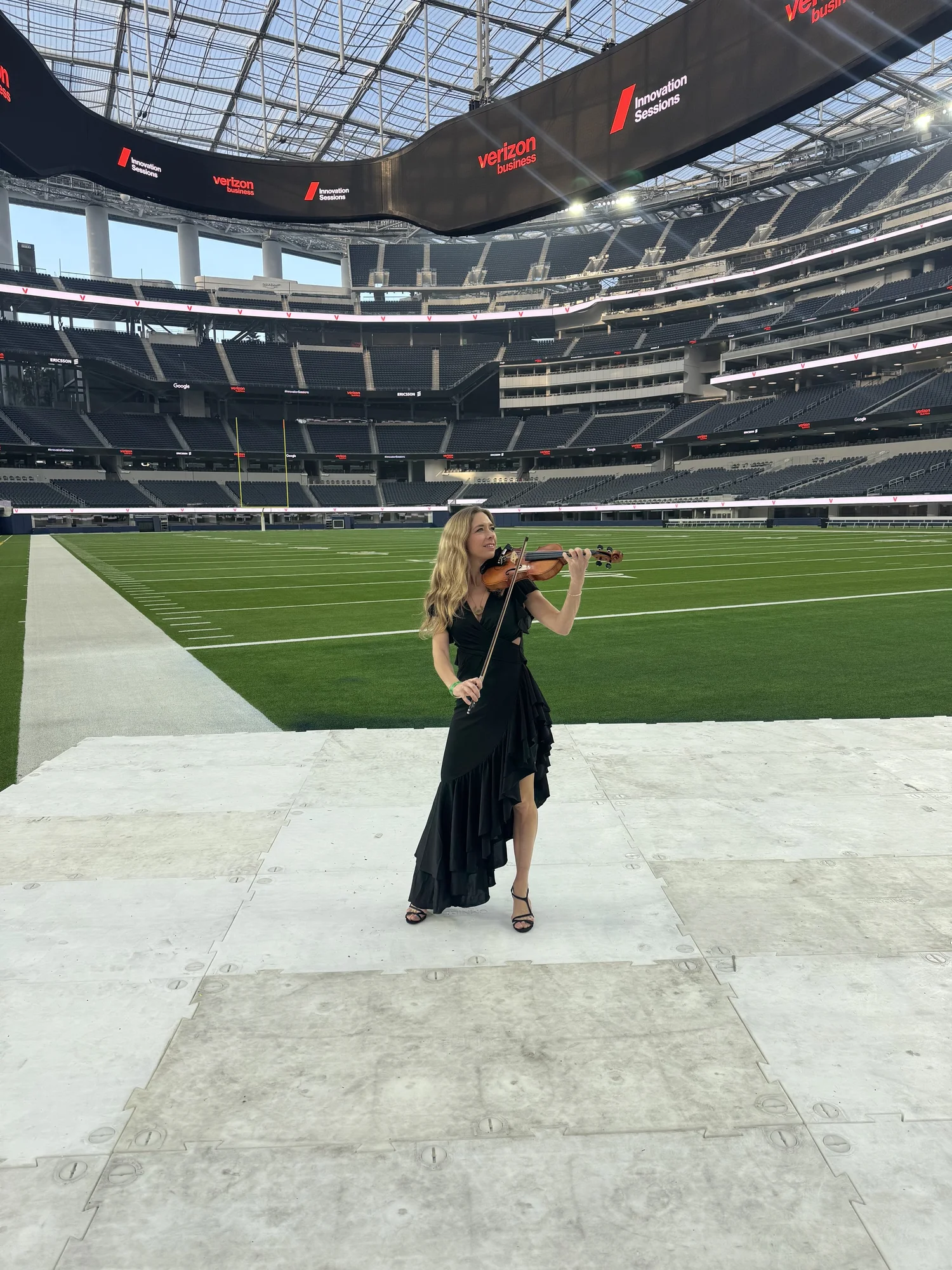 Elin Wolf performing violin on the field at SoFi Stadium